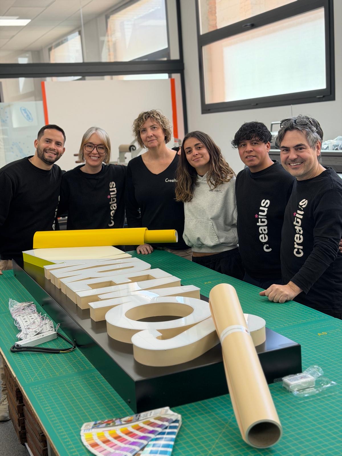 Equip de Creatius.cat al taller preparant un rètol lluminós